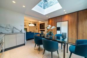 哈罗盖特Westcourt by RMG Apartments的一间设有玻璃桌和蓝色椅子的用餐室
