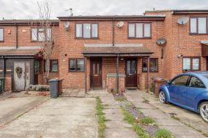 达格纳姆Lovely House in Dagenham / Barking with free parking, WiFi & Garden的前面有一辆蓝色汽车的砖房