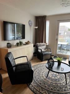 霍勒姆Appartement Ut & Thus, Resort Amelander Kaap的客厅配有沙发、椅子和桌子