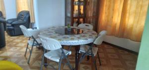 RéunionParadise Resting Home的餐桌周围摆放着白色椅子