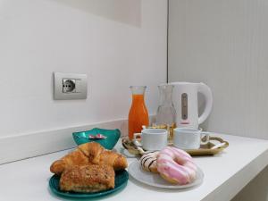 圣特雷莎加卢拉Charme Suite B&B Experience的一张桌子,上面放着两盘糕点和咖啡杯
