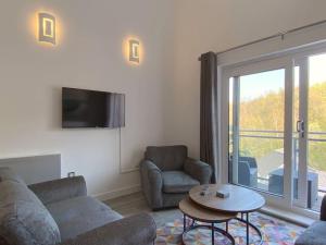 斯旺西Modern Duplex Apartment with Woodland Views的客厅配有沙发、椅子和桌子