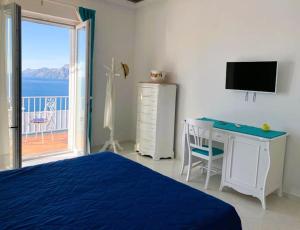 波西塔诺Casa Marrapese的一间卧室配有一张床、一张书桌和一个窗户。