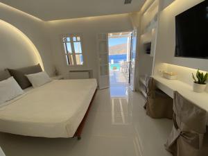 阿莫尔戈斯SeaRock Rooms and Suites的一间白色卧室,配有床和电视