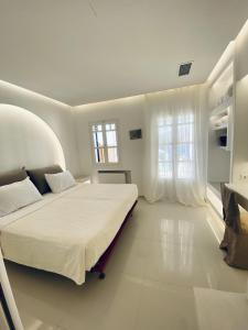阿莫尔戈斯SeaRock Rooms and Suites的白色卧室设有大床和窗户