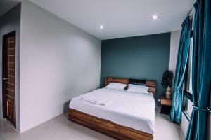 邦波The Living Hotel SamutPrakan的一间卧室设有一张床和蓝色的墙壁