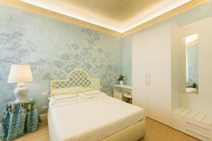 佛罗伦萨Flat Volturno- Florentine neighbourhood的一间卧室配有一张床和一张带花卉壁纸的墙壁