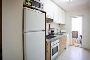 卡巴纳斯·德·塔维拉Apartamento Duja的厨房配有白色冰箱和炉灶。