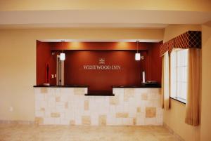 GonzalesWestwood Inn & Suites的大堂墙上挂着西木旅馆标志