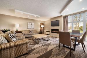 康沃尔康沃尔中心华美达酒店及会议中心的客厅配有沙发和桌子