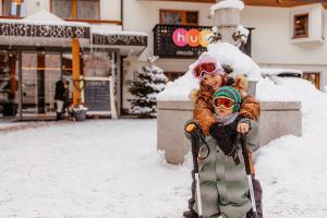瓦勒斯Familienhotel Huber的两个孩子站在雪中