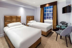 伦敦Radisson Blu Hotel, London Bond Street的酒店客房配有两张床和一张书桌