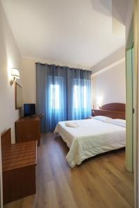 罗马Hotel Laura的一间卧室设有一张大床,铺有木地板