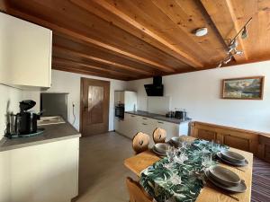 塞格Ferienwohnung Haus Brenner的一间厨房和带木制天花板的用餐室