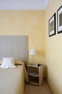 米兰Hotel Colombia的一间卧室配有一张床和一张带台灯的桌子