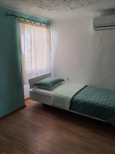 科佩尔Hostel Martin的一间卧室设有一张床和一个带绿色枕头的窗户