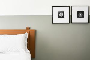 弗洛里亚诺波利斯Apartamentos completos ao lado da UFSC - NAVONA的卧室配有三幅墙上的照片和一张床