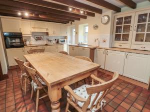 莫珀斯The Granary的一个带木桌和椅子的大厨房