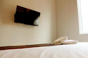 怡保艺术小屋酒店的卧室配有一张床铺,墙上配有电视
