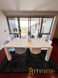 堪培拉Spacious 1bd Penthouse - Close to ANU的窗户客房内的白色桌椅