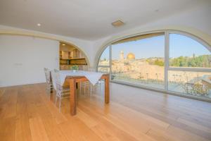 耶鲁沙拉伊姆Western Wall View Apartment的一间配备有桌子的用餐室,享有城市美景。