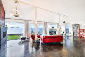 阿尔特费尔Panoramalodge Rügen的客厅设有红色的沙发和大窗户