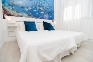 拉雷斯廷加Marinero的白色卧室配有一张带蓝色枕头的大床