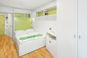 维也纳myNext - Hotel Leo的卧室设有白色的床和绿色的墙壁