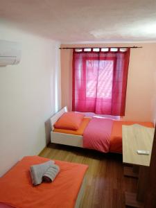 科佩尔Hostel Martin的一间卧室设有两张床和粉红色的窗户。