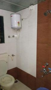 马哈巴莱斯赫瓦尔Krishna Niwas的浴室设有卫生间,墙上挂有水桶