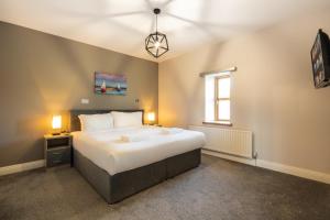 恩尼斯基林Escape Ordinary at Castle Hume的卧室设有一张白色大床和一扇窗户。