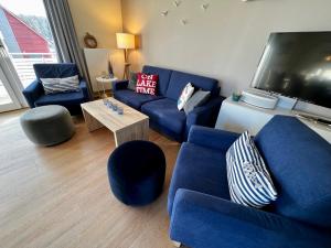 普劳西Anker 39的客厅配有蓝色的沙发和电视