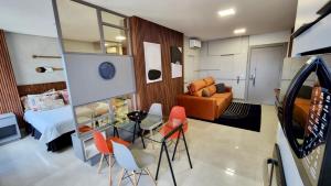 大坎普Estúdio Ultra Luxo com Vista Panorâmica的小房间设有一张床、一张桌子和椅子