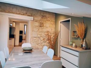 索米尔Maison chaleureuse située à Saumur的一间带桌子和白色椅子的用餐室