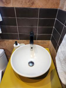 拉罗马纳Hotel La Casona MC的浴室黄色柜台上的白色水槽