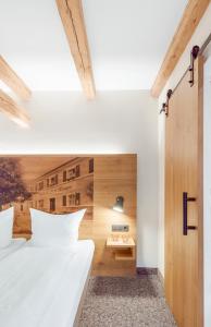 WeigendorfZum Alten Fritz的一间卧室设有两张白色的床和木墙