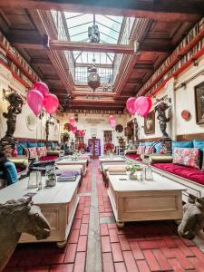 班斯卡 - 什佳夫尼察Divná pani Luxury Gallery Rooms的一间餐厅,在房间内配有桌子和粉红色气球