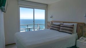 维纳德马神庙公寓酒店的一间卧室设有一张床,享有海景
