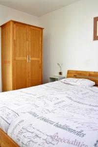 克莱沃Ferienwohnung Die Himmlische的一间卧室配有一张大床和一个木制橱柜