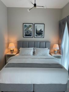 迪拜MAG 565, Boulevard, Dubai South, Dubai的一间卧室配有一张带两盏灯的大型白色床。