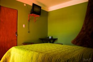 乌玛瓦卡Alto Independencia的卧室配有一张床,墙上配有电视。