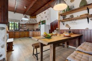 洛斯雷亚莱霍斯Finca Viña Maria的厨房配有木制橱柜和木桌。