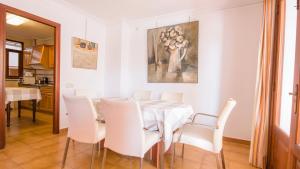 卡拉博纳Vives Ref 9002的一间带桌子和白色椅子的用餐室