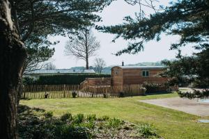 兰迪德诺Luxury Twin Shepherds Hut - Cosy & Romantic的院子中的木屋,设有围栏
