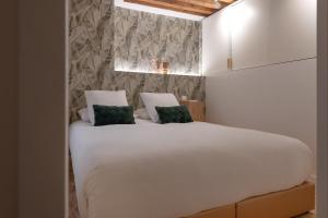 里昂MiHotel Georges的卧室配有白色床和2个绿色枕头
