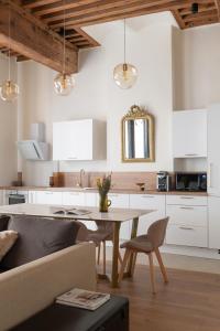 里昂MiHotel Georges的厨房配有白色橱柜、桌子和沙发