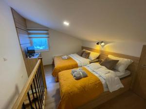 亚霍里纳Vila Jahor Superior Apartman 16 “Minja”的配有黄色床单的客房内的两张床