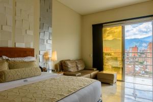 麦德林多拉多70号酒店的一间卧室配有一张床、一张沙发和一个窗口