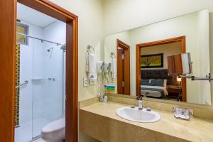 麦德林多拉多70号酒店的一间带水槽、淋浴和镜子的浴室
