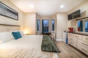 新格拉斯哥Riverside Inn的卧室配有一张白色大床和电视。